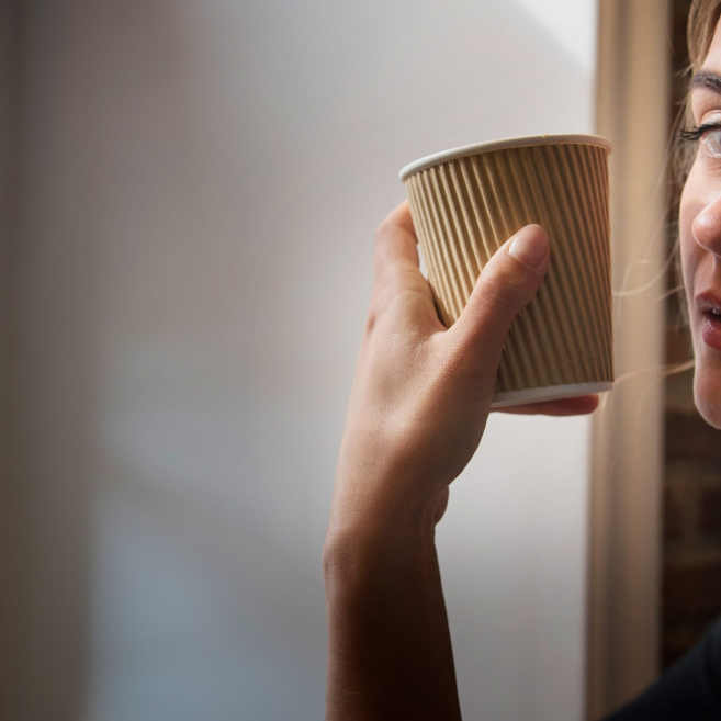 Blonde in a cafe with a paper Cup in hand
